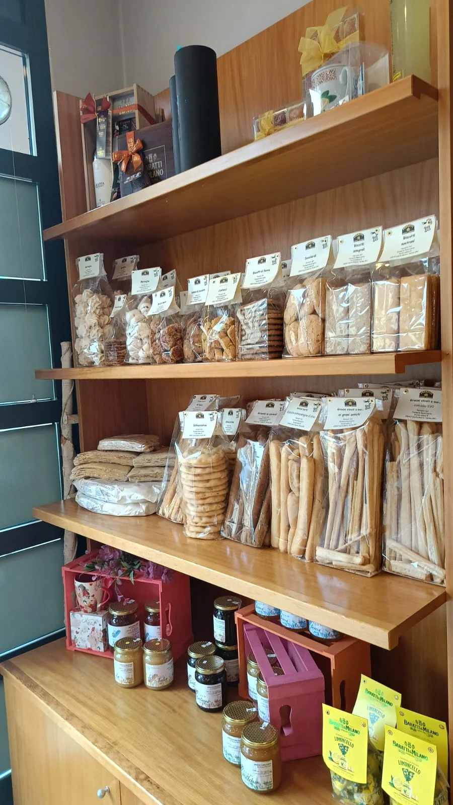 Scaffale con biscotti, grissini, miele e marmellate